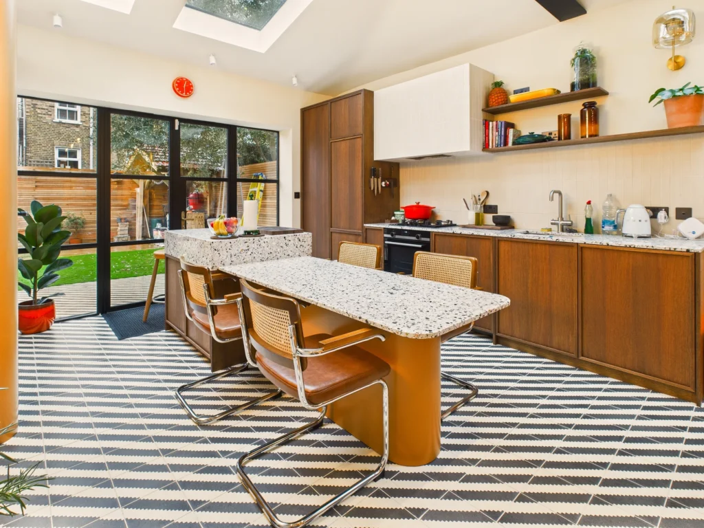 Kitchen extension in Bow with oak cabinets, terrazzo worktops and glazed doors to the garden