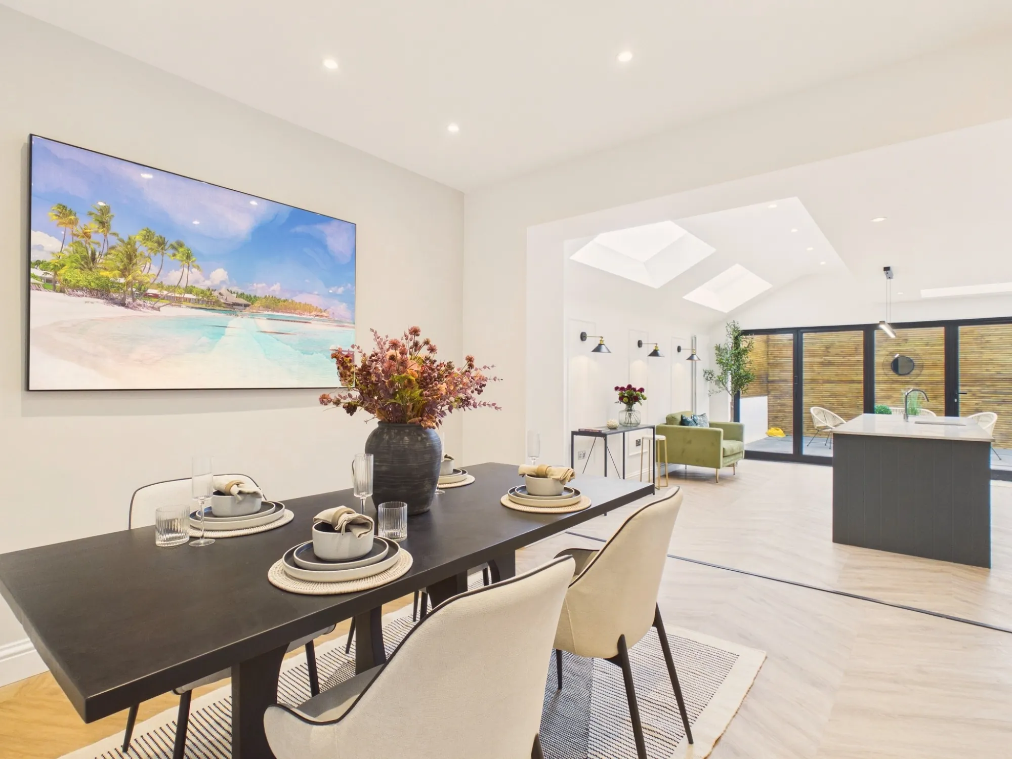 Dining room opening into the wraparound extension, with rooflights, wall lights and bifold doors to the garden