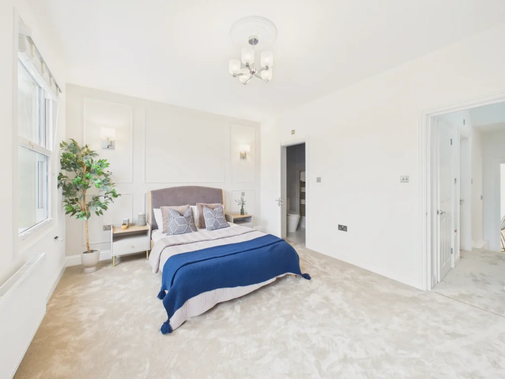 Master bedroom with a panelled bed wall and a door through to its ensuite